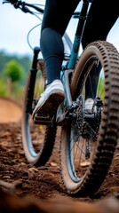 Naklejka premium Mountain Biker Rides on Trail with Muddy Tires in Nature Setting