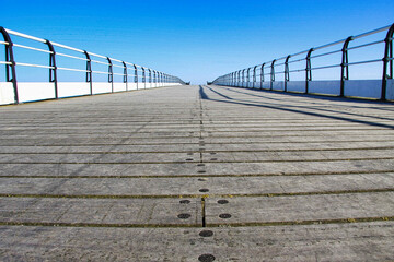 Pier at low level boardwalk looking into a bright blue sky