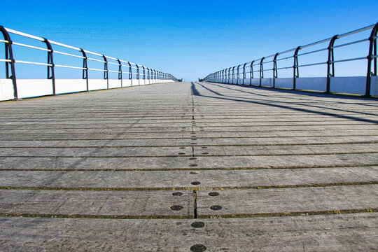 Pier at low level boardwalk looking into a bright blue sky - Powered by Adobe