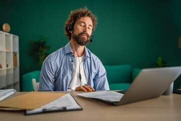 Business professional meditating at work desk