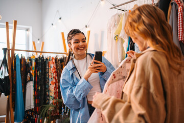 Two good friends are having a great time shopping together at a trendy clothing store