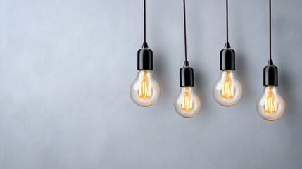 Naklejka premium A modern arrangement of hanging light bulbs against a gray wall, creating an aesthetic and contemporary interior decor.