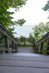 Wooden staircase through greenery leading to Lake Michigan beach