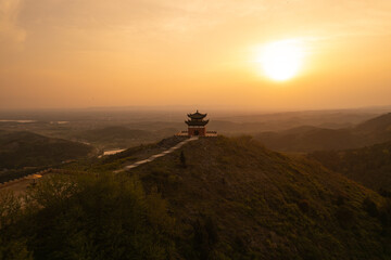 A scenic view of Baizhao Mountain with a pavilion at sunset.