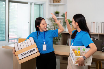 Volunteer teamwork in donation drive, celebrating contributions with joy