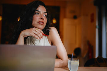 Pensive woman pauses during digital work, reflecting emotional presence and creative processing, blending tech tools with human depth and personal expression.