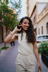 Confident woman lifts phone mid-conversation, showing engagement and connection, embodying seamless...