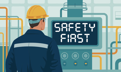 Worker wearing hard hat and safety glasses looking at safety first sign in industrial plant environment, promoting workplace safety and accident prevention