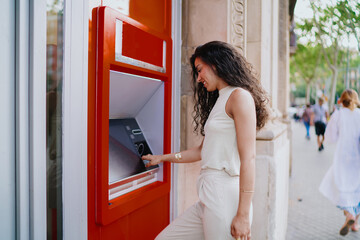 Woman at ATM looking aside, symbolizing awareness, security, and trust in using modern banking technology in public spaces.