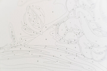 A set of small, numbered acrylic paint pots for a paint-by-numbers kit, sealed in plastic and resting on top of the corresponding canvas with its numbered outlines.