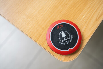 Service call system on wooden desk surface in restaurant