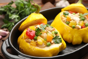 Tasty stuffed pattypan squashes in baking dish on table, closeup
