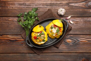Tasty stuffed pattypan squashes in baking dish on wooden table, flat lay