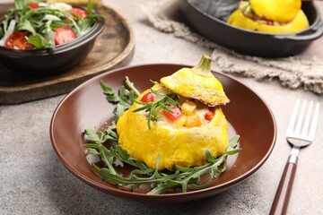Tasty stuffed pattypan squash with arugula served on grey table, closeup