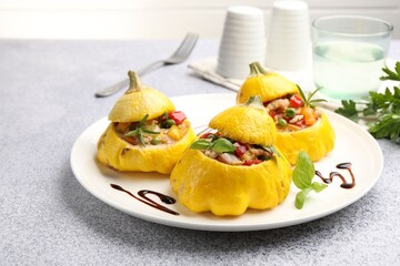 Tasty stuffed pattypan squashes on grey table, closeup