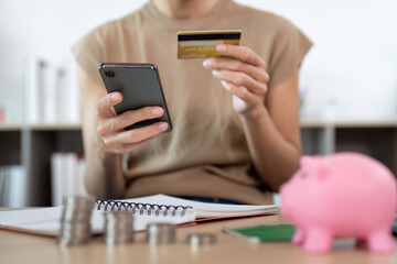 Smart Spending. A woman using a smartphone and credit card for online shopping.