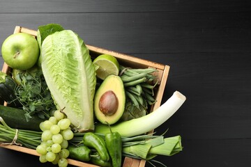 Superfood. Healthy food products in crate on black wooden table, top view. Space for text
