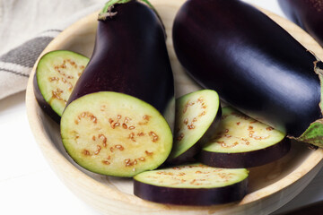 Whole and cut eggplants on white table, closeup