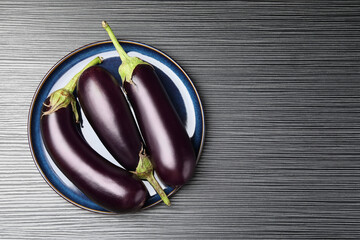 Many ripe eggplants on black wooden table, top view. Space for text