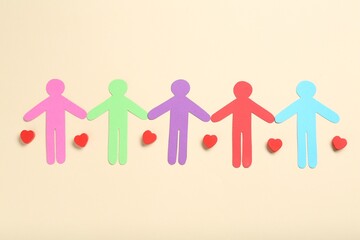 Tolerance concept. Colorful human figures and hearts on beige background, flat lay