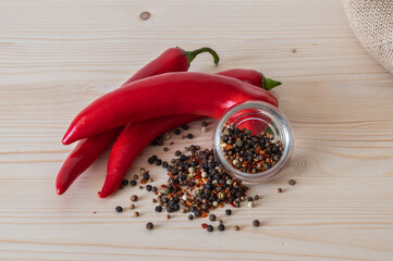 The pods  of red chilli pepper, black peppercorn on wooden table.
