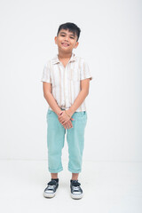A well behaved young asian boy standing in a full body shot with his hands held together in front, smiling brightly and radiating joy with a calm and cheerful presence. Isolated on a white background. © Mdv Edwards