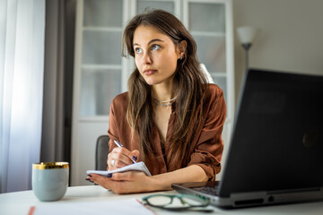 Young Woman Working from Home Writing Notes