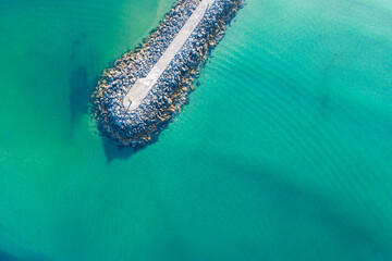 A Top Down Drone Shot of a Pier in a Turquoise Ocean. Concept A beautiful and minimalist coastal scene.
