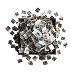 Box overflowing with old photos, some spread around. Top-down view, scattered