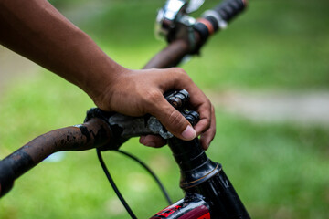 Closeup of a persons hand gripping the handlebar of a bicycle
