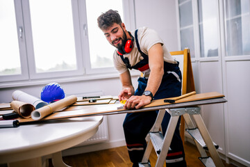 Obraz premium Repairman Measuring Laminate Flooring