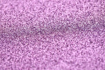 Beautiful purple glitter sparks texture as background with shallow depth of field