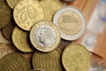 Many cent coins of euro currency lies on many fifty euro bills banknotes