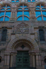 closeup of the entrance of an massive medieval building in germany with reliefs and iron door and window grilles 