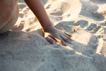 Kid enjoying warm sand at beach on sunny day