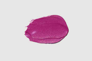 Cosmetic make-up beauty product. Matte dark pink fuchsia maroon lipstick swatch isolated on neutral...