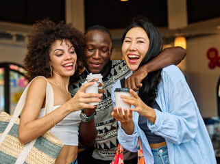 Portrait of group of young people drinking coffee in coffee shop city street, walking together and having fun.