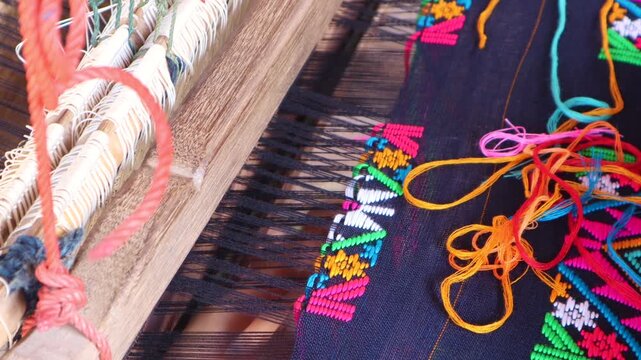 Close up footage Women weaving silk in a weaving village of Thailand.
