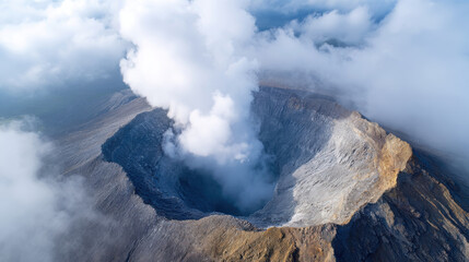 Fototapeta premium Aerial view of volcanic crater with steam rising, surrounded by rugged terrain and clouds, creating dramatic and powerful natural scene