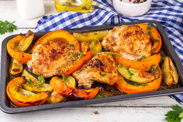Roasted baked chicken thigh with pumpkin and potato wedges