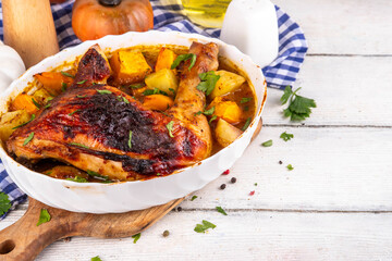 Roasted baked chicken quarter with pumpkin and potato stew, garlic and aromatic herbs. Tasty autumn...