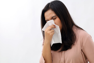 Closeup photo of beautiful young Asian woman is sick, feverish, sneezing, suffering from cold,...