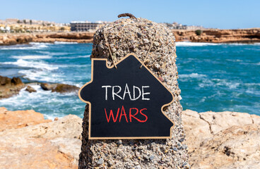 Trade wars symbol. Concept word Trade wars on beautiful black blackboard. Beautiful stone and blue...