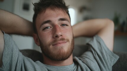 Obraz premium Young man relaxing at home with a smile in a cozy living room during the late afternoon