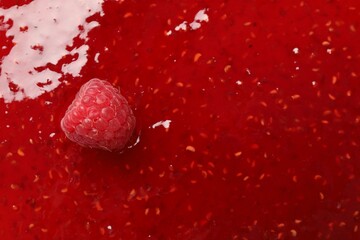 Delicious raspberry jam with fresh berry as background, top view