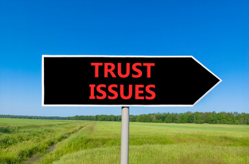 Trust issues symbol. Concept word Trust issues on beautiful black road sign. Beautiful green grass...