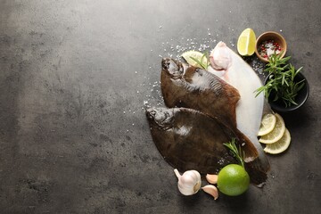 Fresh flounder fish, spices and products on grey textured table, flat lay with space for text. Raw...