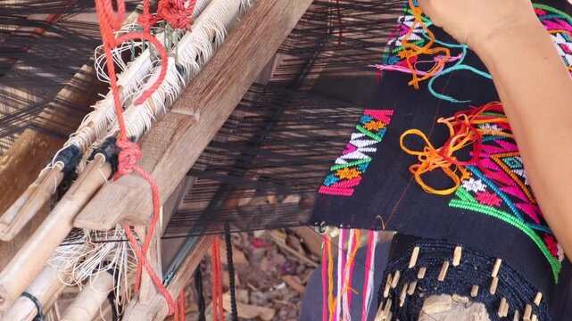 Close up footage Women weaving silk in a weaving village of Thailand.
