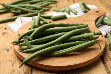 Many raw green beans on wooden table, closeup