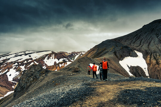 Group of hikers walking on volcanic mountain of Blahnukur trail in overcast at Landmannalaugar, Icelandic Highlands